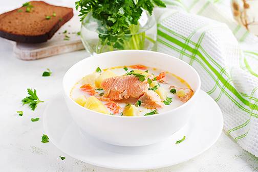 creamy soup with salmon potatoes onions and carrot
