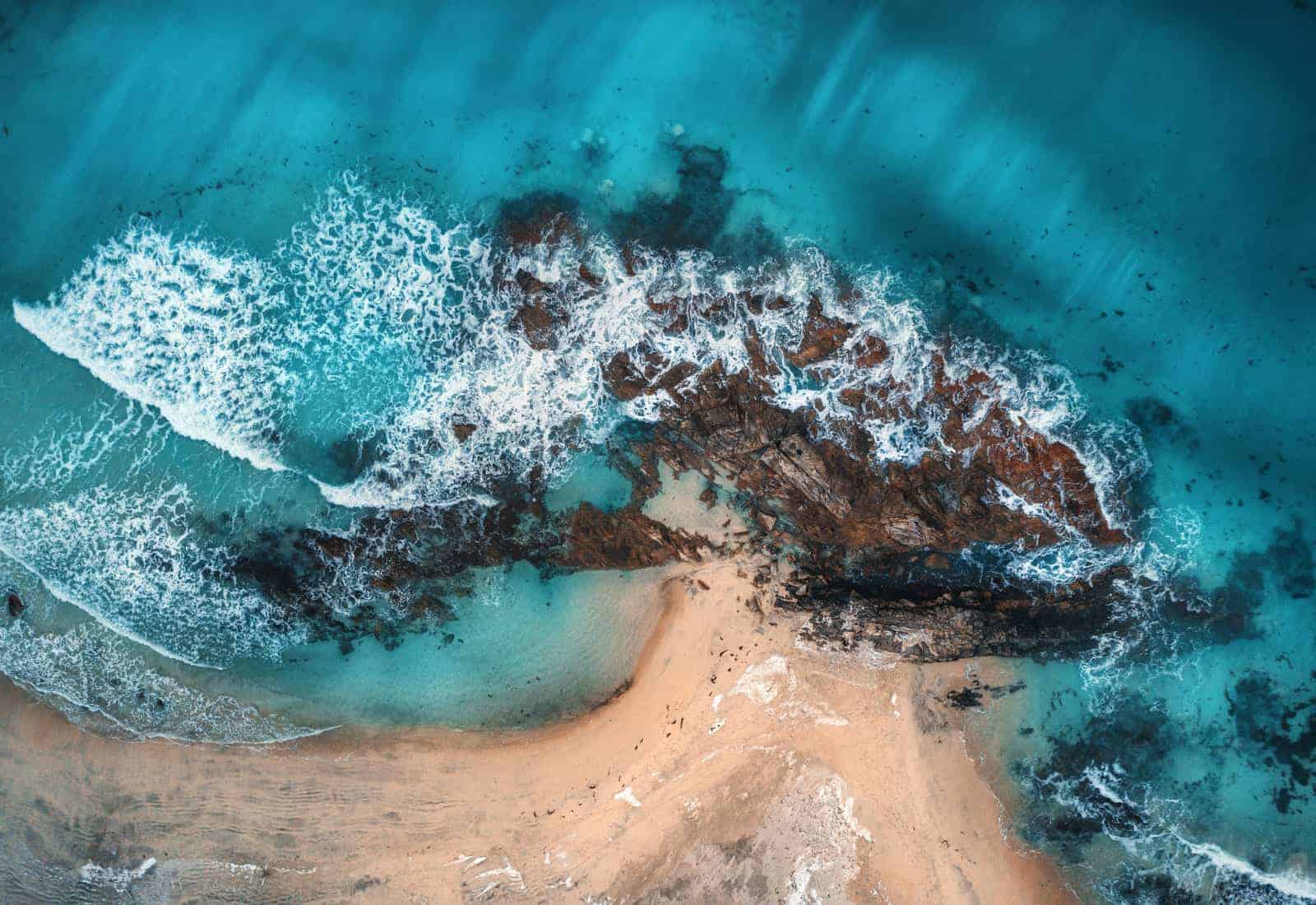 aerial view of waves rocks and transparent sea PYQ8E3R
